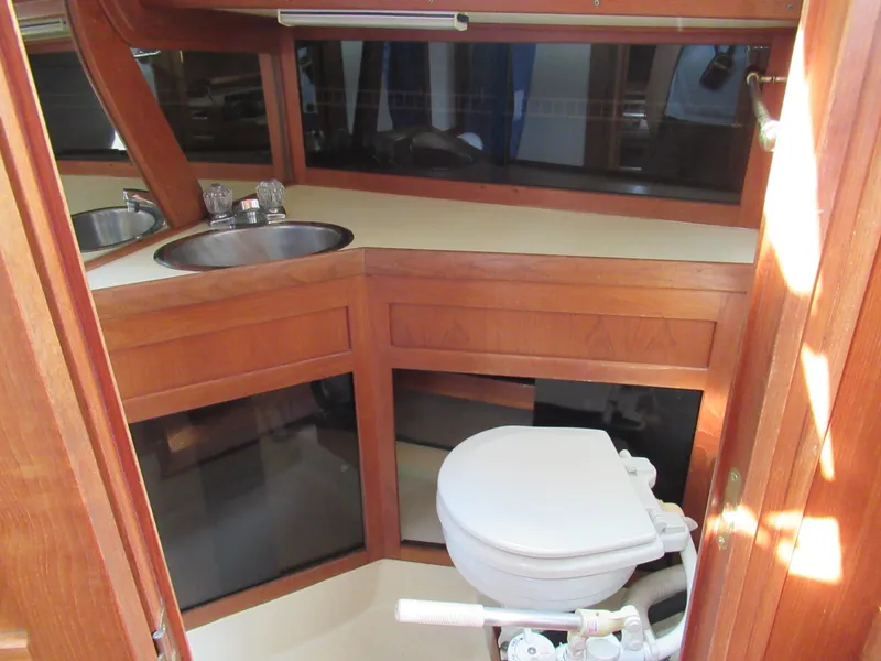 Slide: The Image of Interior of 1980 Fast Passage 39 sailboat with wooden cabinetry and compact marine toilet. - 11