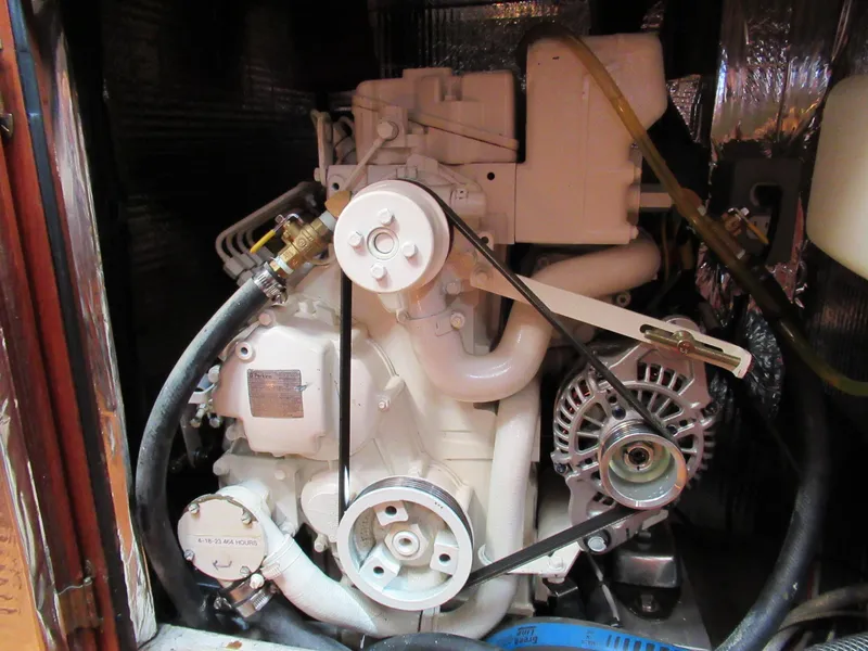 Slide: The Image of Engine of 1980 Fast Passage 39 sailboat, featuring belts and hoses in a compact space. - 13