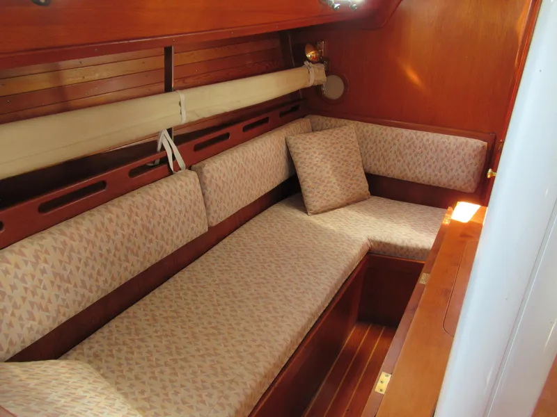 Slide: The Image of Interior of 1980 Fast Passage 39 sailboat with cushioned seating and wooden finish. - 6