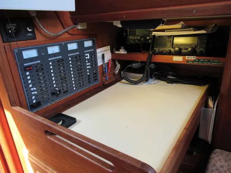 Slide: The Image of Navigation station of a 1980 Fast Passage 39 sailboat with control panels and communication equipment. - 8