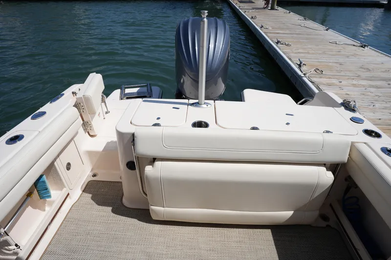 Slide: The Image of 2022 Grady-White Freedom 235 boat interior with outboard motor at dock. - 13