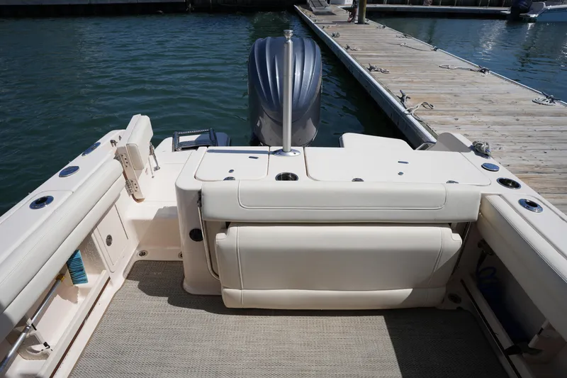 Slide: The Image of 2022 Grady-White Freedom 235 boat interior at dock, featuring spacious seating and motor. - 14
