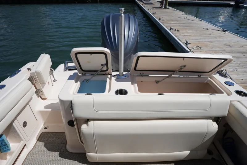 Slide: The Image of 2022 Grady-White Freedom 235 boat with open storage compartments at dockside. - 15
