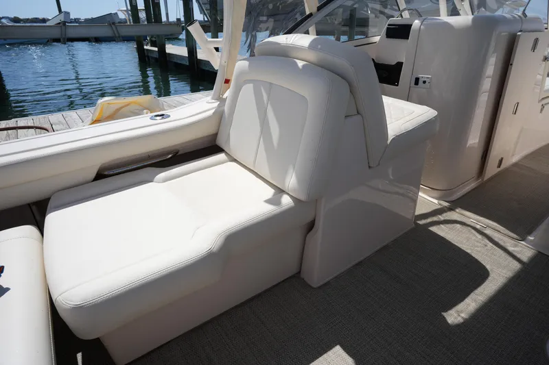 Slide: The Image of 2022 Grady-White Freedom 235 boat interior with white seating and waterfront view. - 21