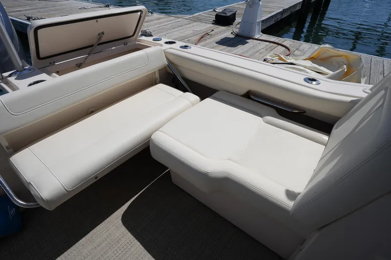 Slide: The Image of 2022 Grady-White Freedom 235 boat interior with beige seating near a dock. - 22