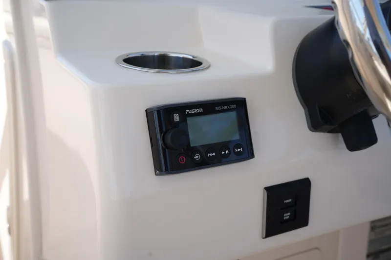 Slide: The Image of 2022 Grady-White Freedom 235 boat dashboard with Fusion stereo system and cup holder. - 25