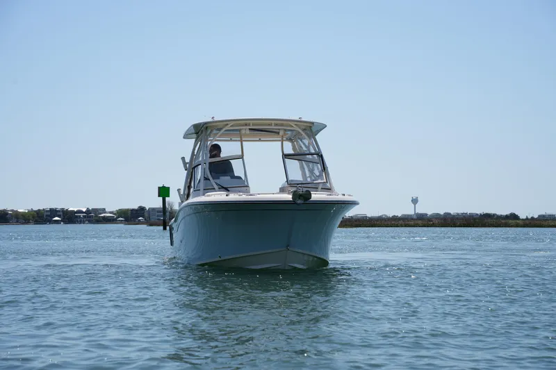 Slide: The Image of 2022 Grady-White Freedom 235 boat cruising on calm water under clear sky. - 3