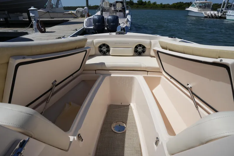 Slide: The Image of 2022 Grady-White Freedom 235 boat interior with open storage compartments at a marina. - 34