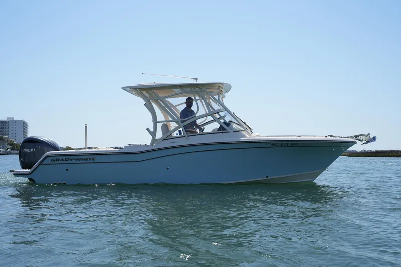 Slide: The Image of 2022 Grady-White Freedom 235 boat cruising on calm water under clear sky. - 7