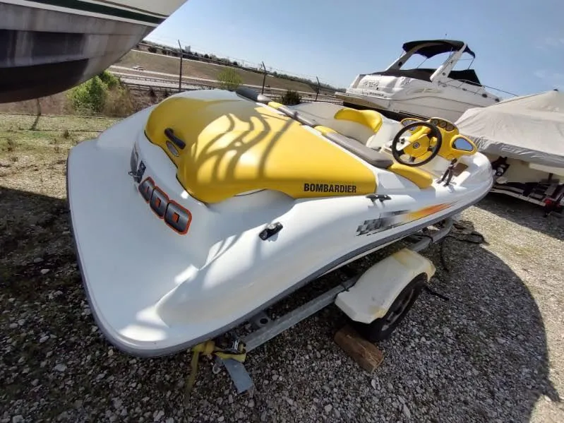 Slide: The Image of 2004 Sea-Doo Sportster boat with yellow accents on a trailer, parked outdoors. - 3