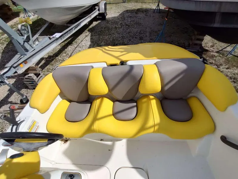 Slide: The Image of 2004 Sea-Doo Sportster boat with yellow and gray seating, parked on a trailer. - 4