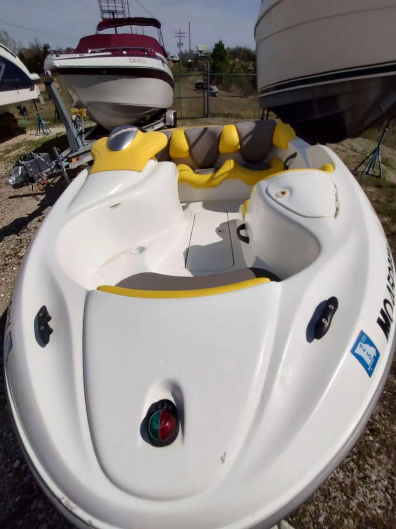 Slide: The Image of 2004 Sea-Doo Sportster boat with yellow seating, parked among other boats. - 6