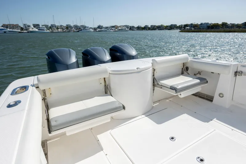Slide: The Image of 2017 Everglades 355 Tournament boat with triple engines, spacious deck, and seating, on calm water. - 14