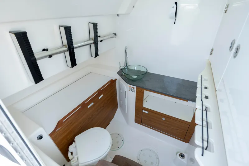 Slide: The Image of Interior of 2017 Everglades 355 Tournament boat, featuring a compact bathroom with modern amenities. - 26