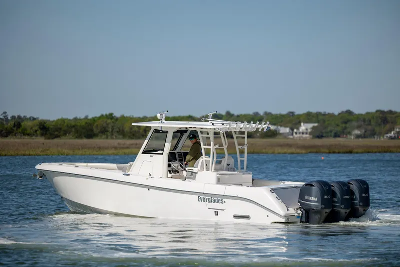 Slide: The Image of 2017 Everglades 355 Tournament boat cruising on a calm lake with triple outboard engines. - 3
