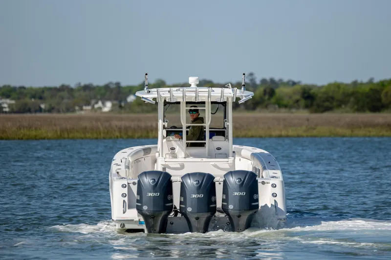 Slide: The Image of 2017 Everglades 355 Tournament boat with triple engines cruising on a calm lake. - 5