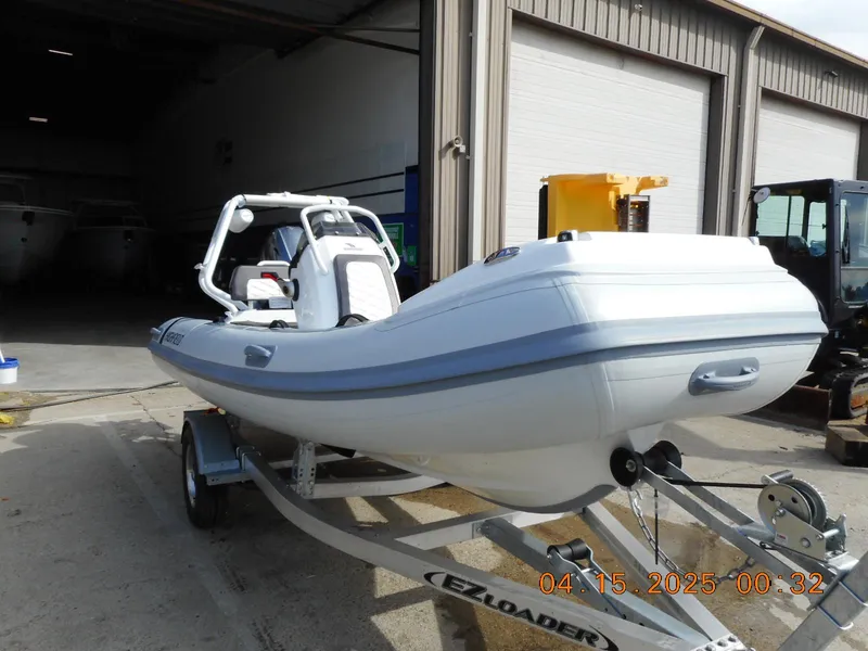 Slide: The Image of 2025 Highfield Sport 420 boat on trailer outside a warehouse. - 3