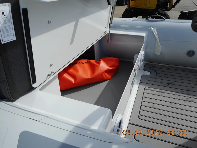 Slide: The Image of Open storage compartment on 2025 Highfield Sport 420 boat with orange bag inside. - 7