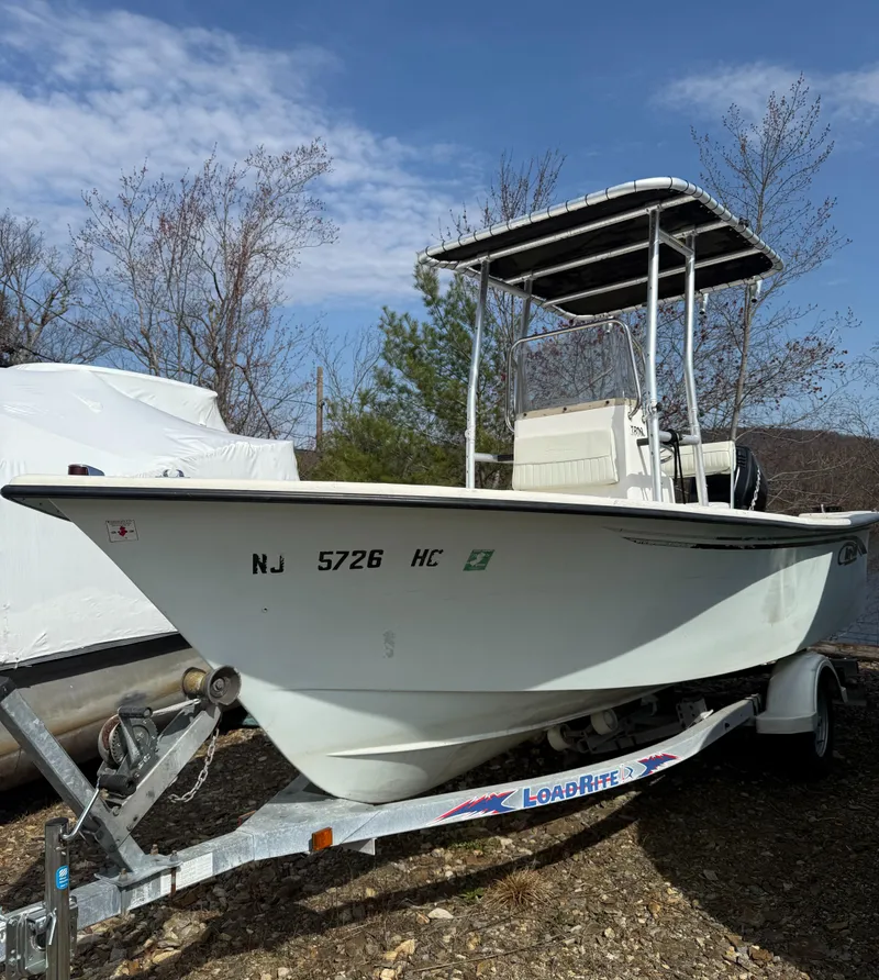 Slide: The Image of 2010 May-Craft 1800 Skiff boat on trailer, parked outdoors under clear sky. - 2