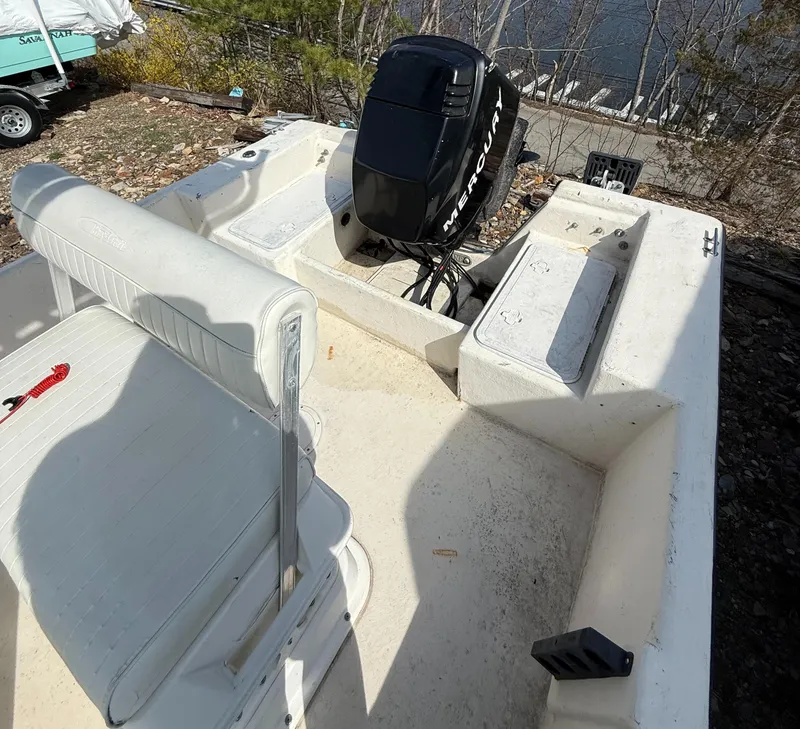 Slide: The Image of 2010 May-Craft 1800 Skiff boat with Mercury outboard motor, white interior, parked near water. - 4