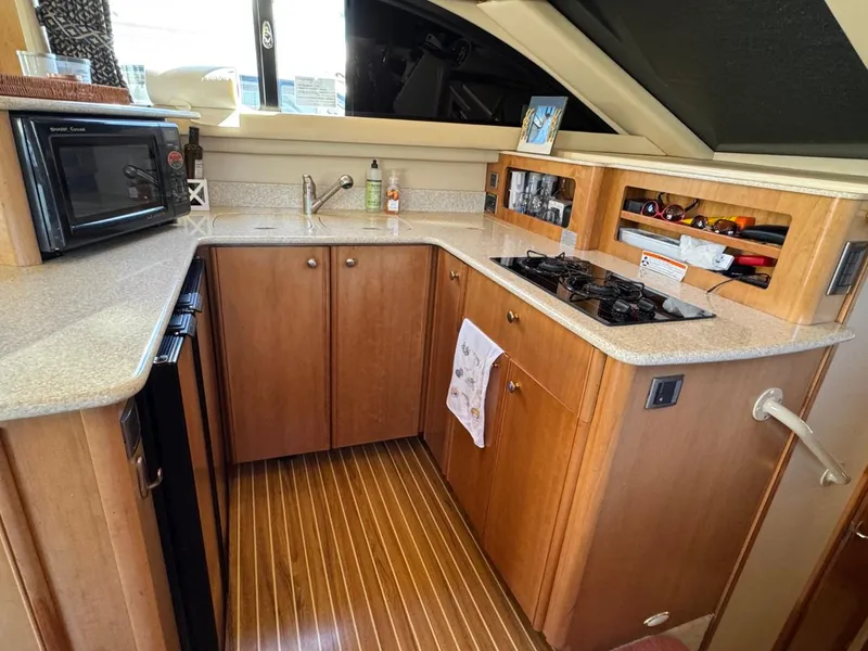 Slide: The Image of Compact kitchen in a 2003 Meridian 381 Sedan yacht with wood cabinetry and modern appliances. - 20
