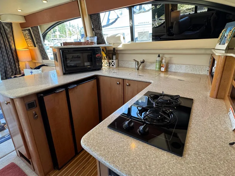 Slide: The Image of 2003 Meridian 381 Sedan kitchen with stove, microwave, and countertop in a cozy interior setting. - 21