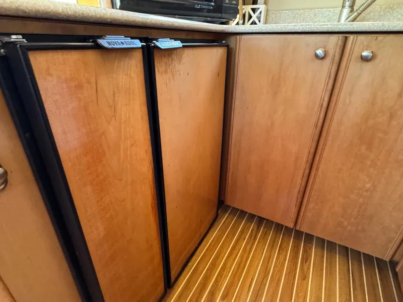 Slide: The Image of Wooden cabinetry and flooring in a 2003 Meridian 381 Sedan yacht kitchen. - 23