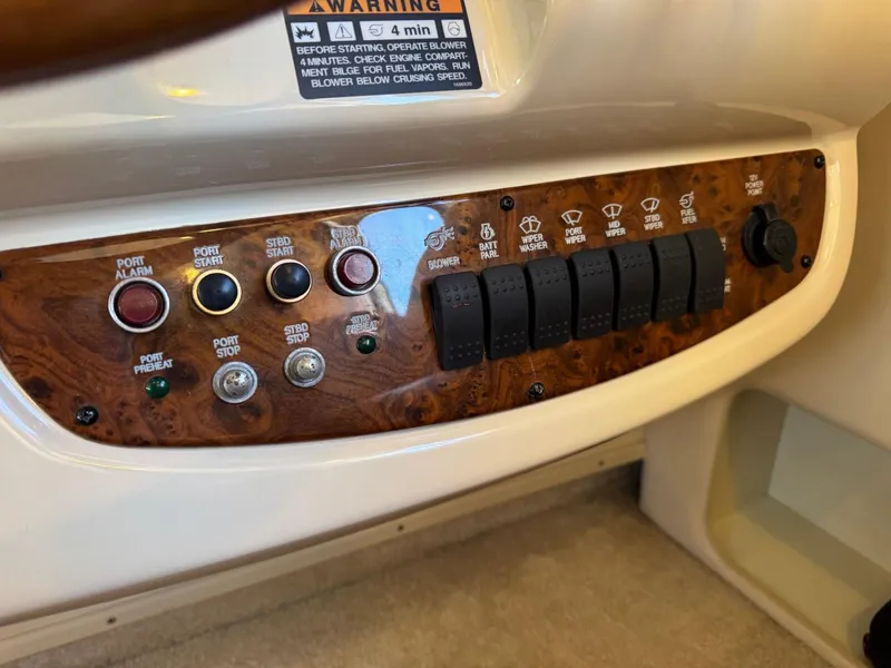 Slide: The Image of Control panel of a 2003 Meridian 381 Sedan boat with various switches and warning label. - 35