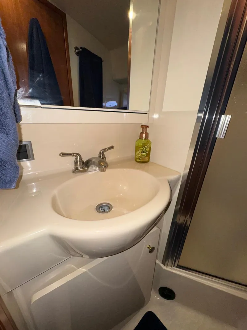 Slide: The Image of Bathroom sink area in a 2003 Meridian 381 Sedan yacht, featuring a faucet and soap dispenser. - 41