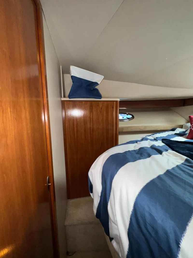 Slide: The Image of 2003 Meridian 381 Sedan cabin interior with wood paneling and striped bedding. - 46