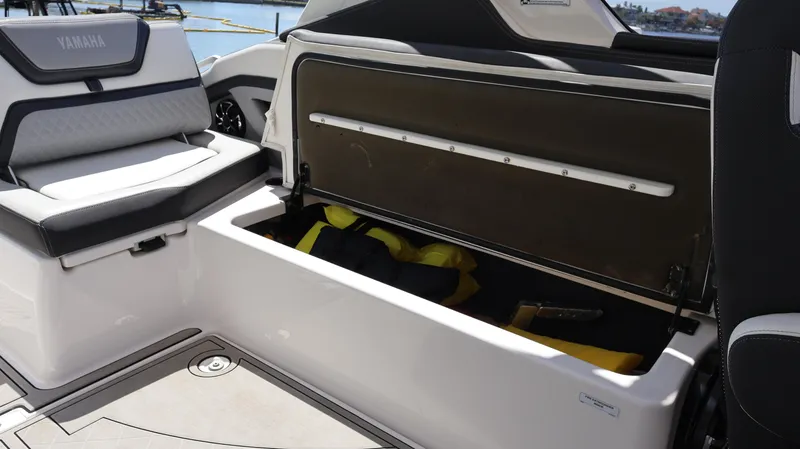 Slide: The Image of 2020 Yamaha Boats 275 SD storage compartment with life jackets on a sunny day. - 26