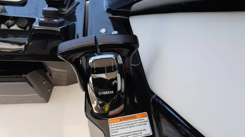 Slide: The Image of Close-up of 2020 Yamaha Boats 275 SD throttle control on a sleek black console. - 30