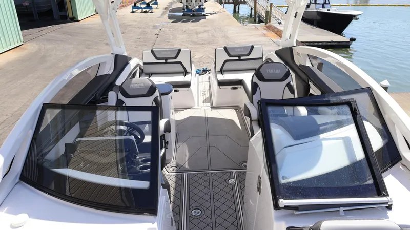 Slide: The Image of 2020 Yamaha Boats 275 SD interior with sleek seating and modern design at a dock. - 42