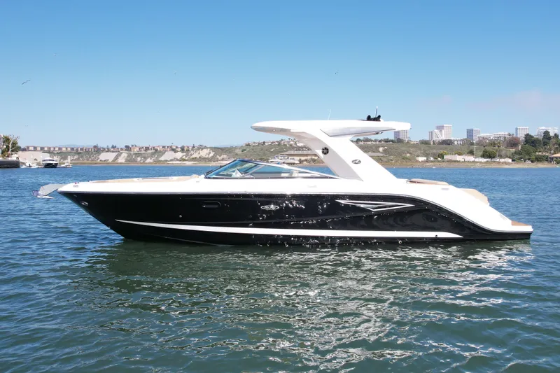 Slide: The Image of 2019 Sea Ray SLX 310 boat on calm water under clear blue sky. - 1