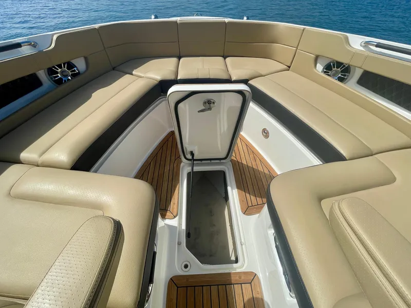 Slide: The Image of Luxurious 2019 Sea Ray SLX 310 boat interior with tan seating and teak flooring. - 25
