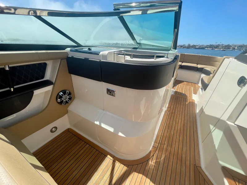 Slide: The Image of 2019 Sea Ray SLX 310 boat interior with teak flooring and sleek design. - 28