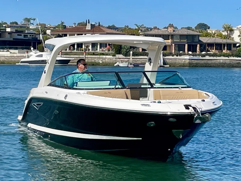 Slide: The Image of 2019 Sea Ray SLX 310 boat cruising on a sunny day in a scenic waterfront area. - 3