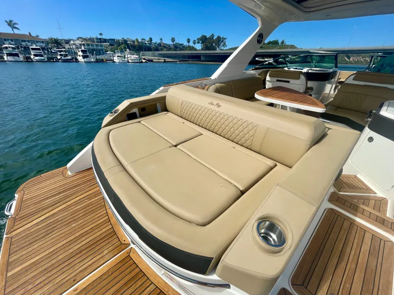 Slide: The Image of Luxurious 2019 Sea Ray SLX 310 boat interior with tan seating and wooden deck. - 46