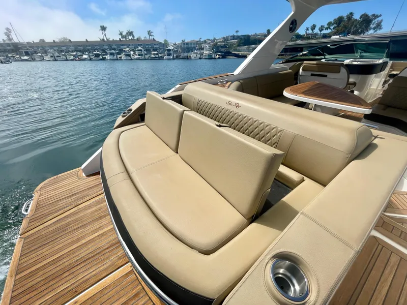 Slide: The Image of 2019 Sea Ray SLX 310 boat with luxurious seating and wooden deck, docked in a marina. - 48