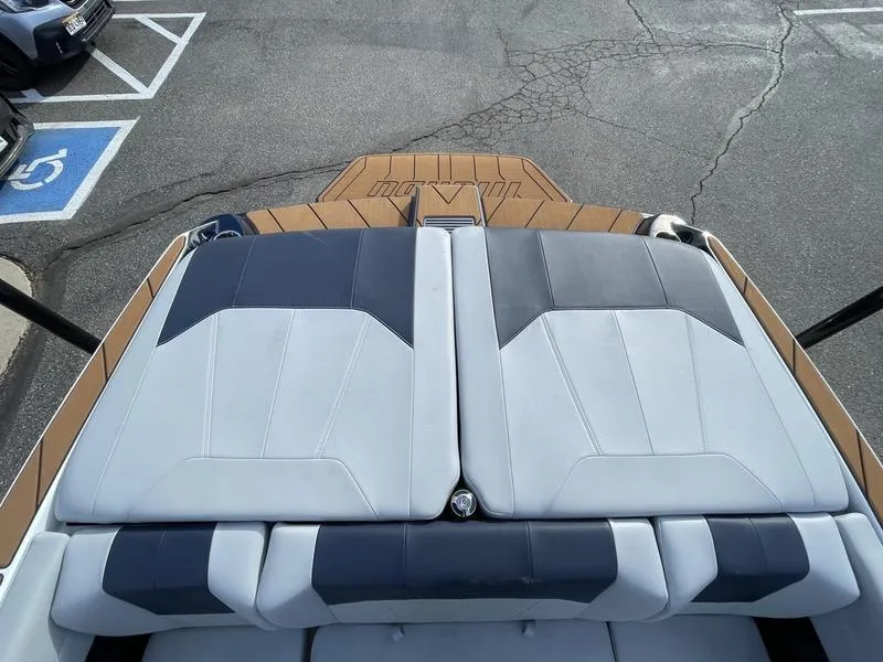 Slide: The Image of 2025 Malibu 20 VTX boat with sleek seating and modern design in a parking lot. - 19