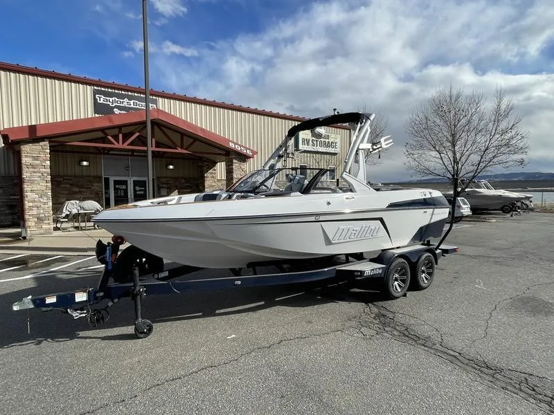 Slide: The Image of 2025 Malibu 20 VTX boat on trailer, parked outside a storage facility. - 3