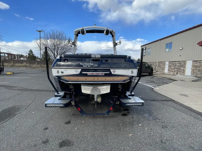 Slide: The Image of 2025 Malibu 20 VTX boat parked outdoors, showcasing rear view and swim platform. - 8