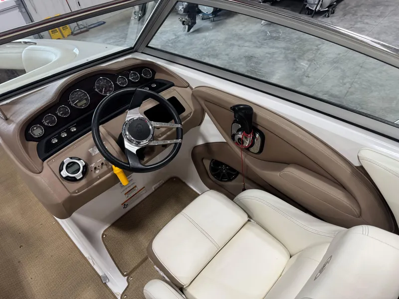 Slide: The Image of Interior of a 2012 Cobalt 262 BR boat, featuring a sleek dashboard and comfortable seating. - 14