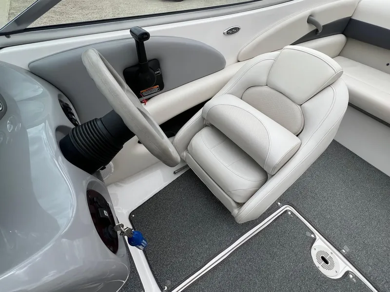 Slide: The Image of Interior of a 2004 Chaparral 210 SSi boat, featuring a steering wheel and captain's seat. - 14