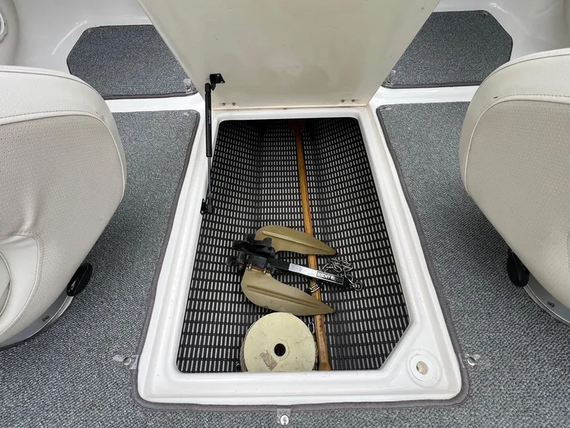 Slide: The Image of Open storage compartment in 2004 Chaparral 210 SSi boat, showing anchor and accessories. - 17