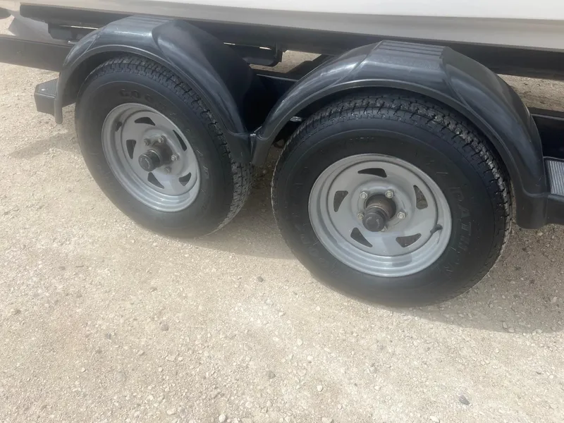 Slide: The Image of Trailer wheels of a 2004 Chaparral 210 SSi boat on a sandy surface. - 30