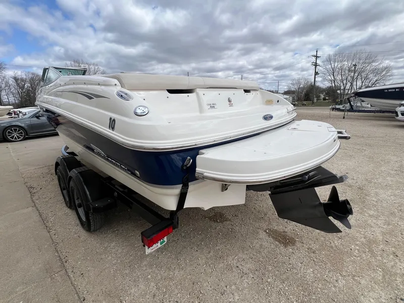 Slide: The Image of 2004 Chaparral 210 SSi boat on trailer, parked outdoors under cloudy sky. - 5
