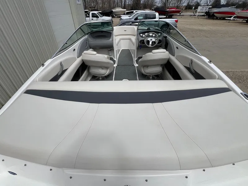 Slide: The Image of 2004 Chaparral 210 SSi boat interior with seating and steering wheel, parked outdoors. - 9
