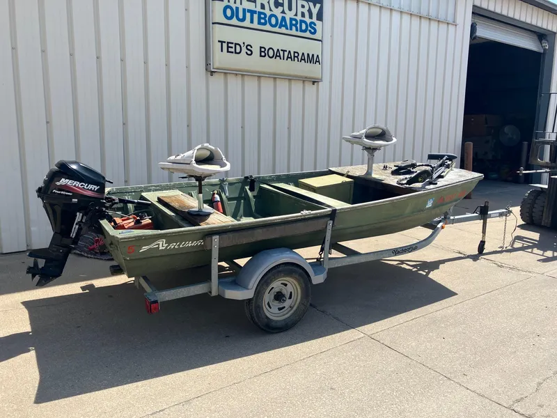Slide: The Image of 1990 Alumacraft 14' Jon boat with Mercury outboard motor on trailer at Ted's Boatarama. - 1