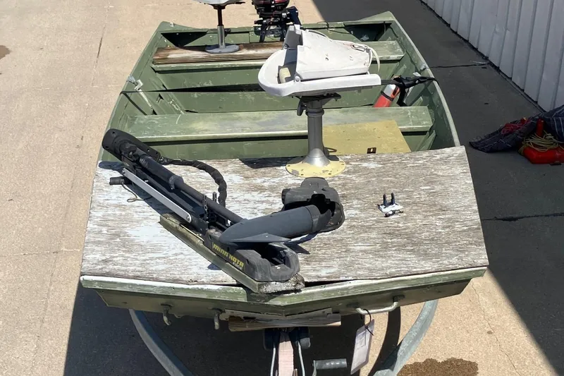 Slide: The Image of 1990 Alumacraft 14' Jon boat with motor, on a trailer, parked outdoors. - 10